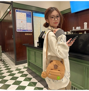 Détail du sac bandoulière Capybara avec oreilles 3D et étiquette M sur modèle
