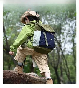 Detail view of green and navy color-block kids hiking backpack with orange cord accents