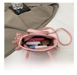 Draufsicht der rosa Beuteltasche mit Geldbörse, Spiegel und Kosmetik im Innenraum