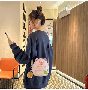 Détail du sac à bandoulière cochon rose avec porte-clé ours en peluche et sangle