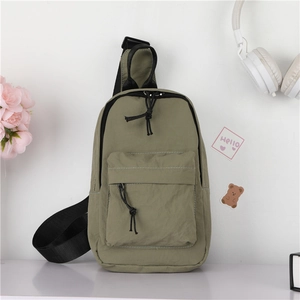 Détail du sac de poitrine en nylon vert avec fermeture éclair à rabat et sangle réglable
