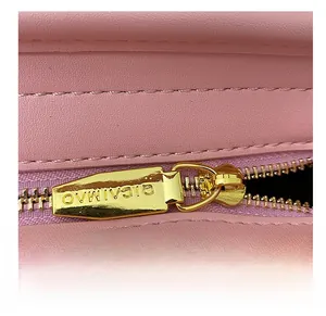 Detailaufnahme des goldenen Metallreißverschlusses an der rosa Leder-Eimertasche für Damen
