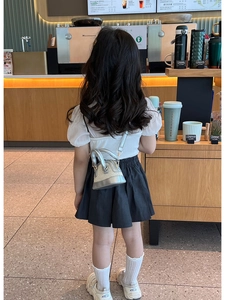 Mini sac bandoulière enfant en paille tissée argentée, présenté sur un mannequin