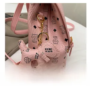 Detail of pink PU leather backpack with cat pattern and dog charm in gold hardware