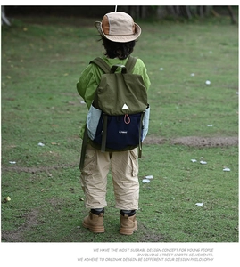 Outdoor back view of a child wearing the navy and green lightweight hiking backpack