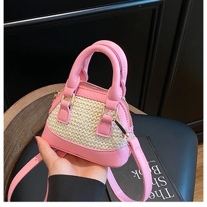 Détails d'un mini sac en paille rose avec fermeture éclair dorée et bandoulière