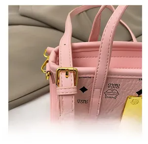 Detailansicht der rosa Beuteltasche mit Katzen-Print und goldenen Metallschnallen