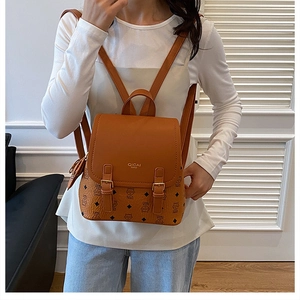 Detailed close-up of brown monogram backpack featuring flip-top flap and buckle straps