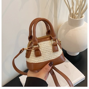 Vue détaillée du mini sac bandoulière en paille avec anses en cuir brun et zips dorés