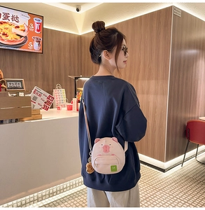 Détail du sac à bandoulière cochon rose avec oreilles 3D et charm en forme de biscuit