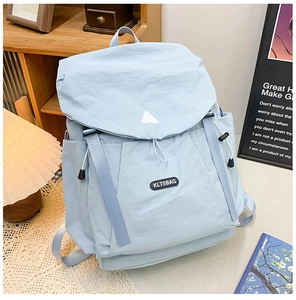 Detail view of light blue waterproof nylon backpack with drawstring side pocket and flap cover