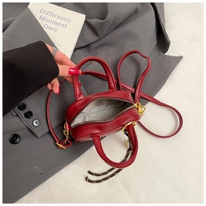 Détail du mini sac bandoulière en cuir PU bordeaux avec poignées et fermeture dorée