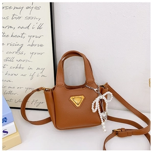 Dettaglio della borsa marrone in pelle per bambina con fiocco di perle e logo