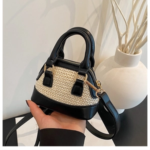 Detailansicht der Mini-Muschel-Tasche mit Kontrast aus schwarzem Leder und beigem Leder und Stroh