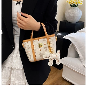 Detail einer Mini-Beuteltasche mit Katzenprints und braunem Lederanhänger