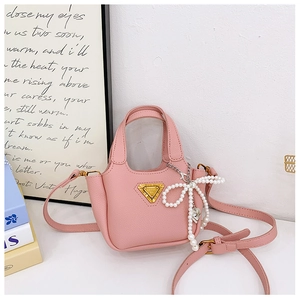 Dettaglio mini borsa rosa con fiocco di perle, logo dorato e tracolla in pelle