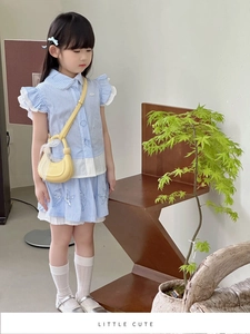 Détail de la tenue d'été rayée bleu clair avec col Claudine et ourlet en dentelle