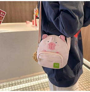 Détail du sac à bandoulière cochon rose avec broderie et porte-clés ours mignon