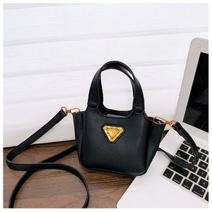 Dettaglio mini borsa nera in pelle martellata con finiture a triangolo dorate su tavolo