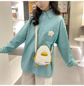 Detail of white canvas crossbody bag featuring a cute cartoon duck design and embroidery