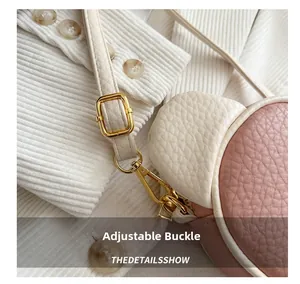 Detail of adjustable golden metal buckle and lobster clasp on pink crossbody bag