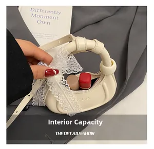 Capacité interne du mini sac en cuir crème montrant l'espace pour rouge à lèvres et maquillage