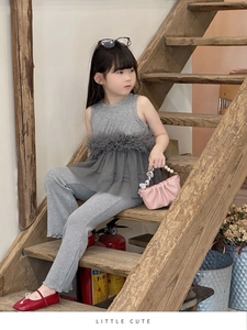 Détail d'un ensemble en tricot gris pour fille avec haut à volants et pantalon évasé