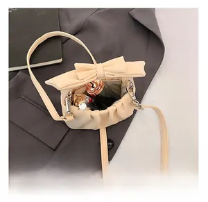Detail showing the inner capacity of this cream cloud handbag with a bow and zipper