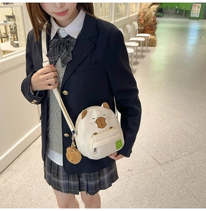 Vue détaillée du sac Capybara blanc avec broderie et pendentif en peluche doux