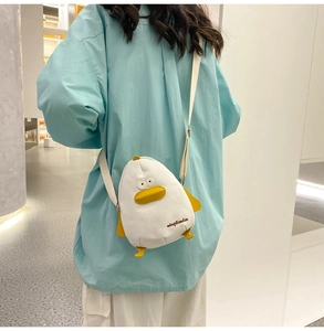 Detail of white canvas crossbody bag featuring a cute yellow duck shape and embroidery