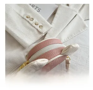 Dettaglio della pelle con grana litchi e cerniera dorata sulla borsa a tracolla a forma di orso