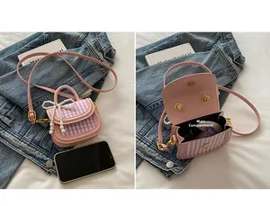 Detail of pink plaid mini bag showing interior main pocket and pearl bow flap closure