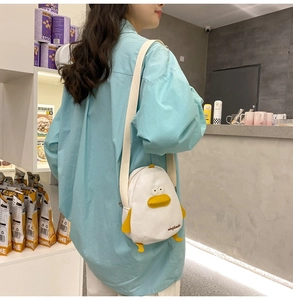 Detail of creative cartoon duck canvas crossbody bag featuring 3D wings and yellow beak