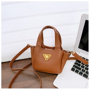 Dettaglio mini borsa a tracolla in pelle marrone con motivo litchi e decoro dorato