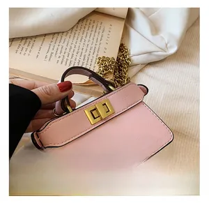 Detail of lychee pattern pink mini bag with golden hardware lock and chain strap
