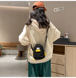 Detail view of mini penguin canvas shoulder bag with yellow duck beak and feet details