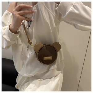 Dettaglio della borsa a tracolla a forma di orso con patchwork di pelle marrone e cinturino