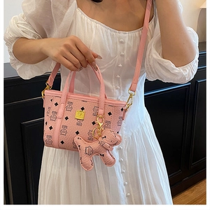 Detailansicht der rosa Beuteltasche mit Katzenprints und kleinem Hunde-Anhänger