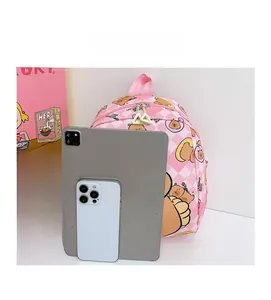 Pink checkered kids backpack with cute bear prints shown next to tablet for size scale