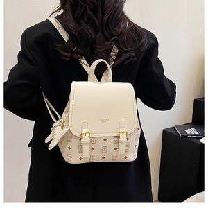 Detail of off-white mini backpack with cat pattern and decorative star charm pendant