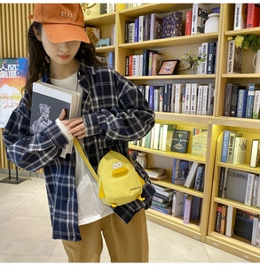 Close-up of a cute yellow cartoon duck canvas crossbody bag worn by a person