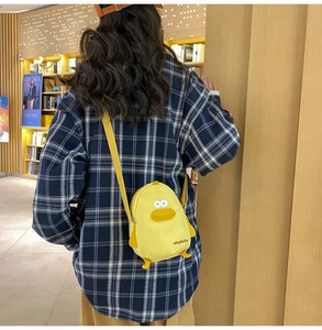 Detail of yellow canvas duck crossbody bag featuring adjustable strap and cute design
