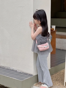 Détail du sac à bandoulière rose plissé pour fille avec chaîne en perles et pendentif cœur