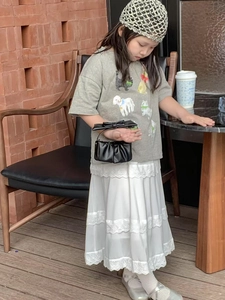 Toddler girl outfit featuring a grey graphic tee and white layered lace skirt