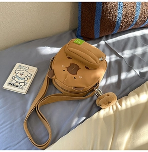 Gros plan détaillé d'un joli sac bandoulière capybara marron avec un porte-clé peluche