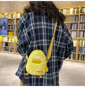 Detail of yellow duck canvas crossbody bag featuring 3D bill and cute feet accents