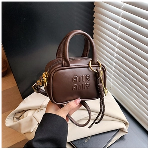 Vue détaillée du mini sac bandoulière en cuir marron pour enfant avec lettres embossées