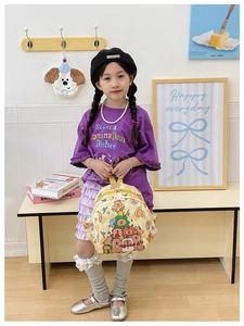 Detail of yellow checkerboard kids backpack featuring cute festive bear illustrations