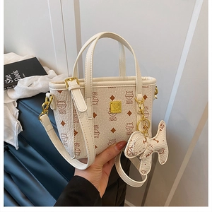 Detailaufnahme der cremefarbenen Ledertasche mit Katzenprint und goldener Hardware