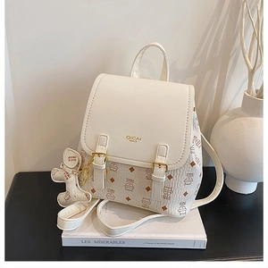 Detail of white mini backpack with cat pattern, brown trim, and cute bear charm